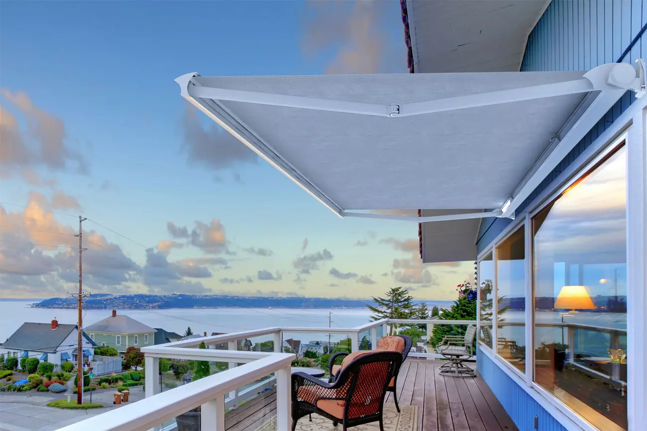Toldo de brazos invisibles extendido sobre una terraza con vista al mar